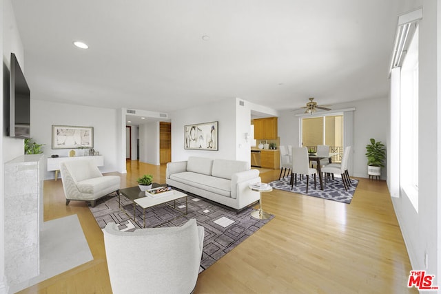 living room featuring light hardwood / wood-style flooring and ceiling fan