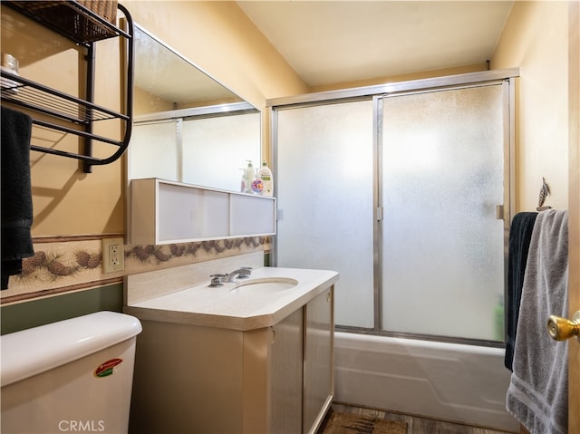 full bathroom featuring vanity, combined bath / shower with glass door, and toilet