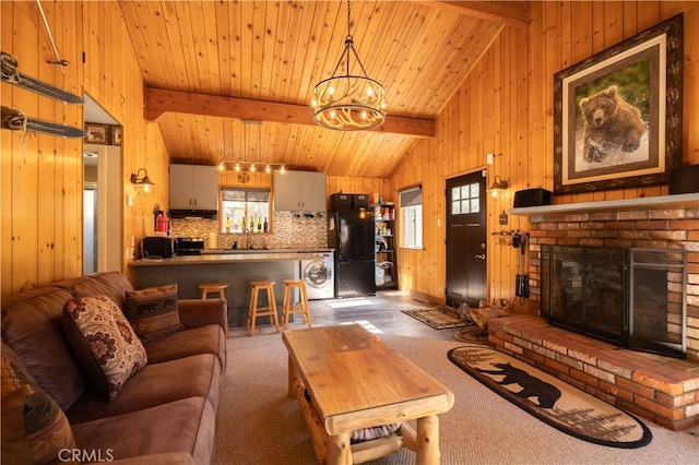 living room with washer / clothes dryer, beamed ceiling, wooden walls, carpet, and sink