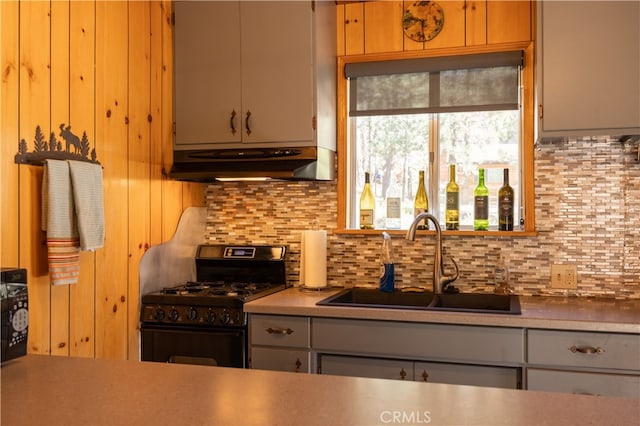 kitchen featuring black gas stove, tasteful backsplash, sink, and ventilation hood