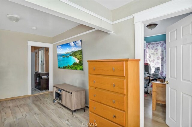 bedroom with ensuite bath and light wood-type flooring