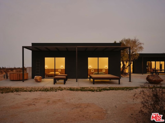 back house at dusk with a patio area