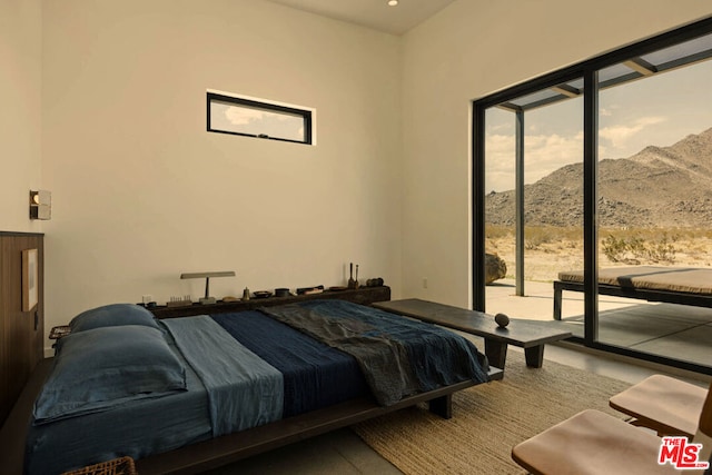 bedroom featuring a mountain view and access to exterior