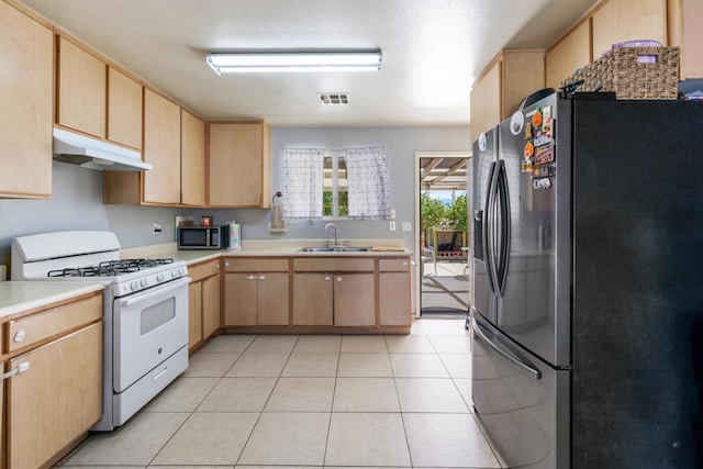 kitchen with light tile patterned floors, stainless steel appliances, sink, and light brown cabinets