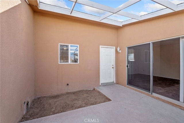 view of exterior entry featuring a patio area