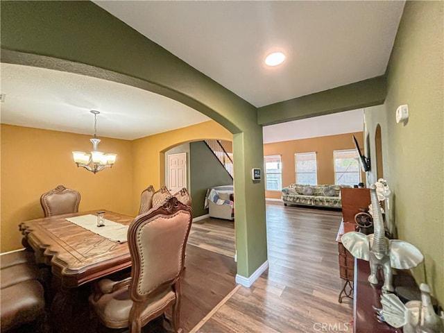 dining area with dark hardwood / wood-style flooring and a chandelier