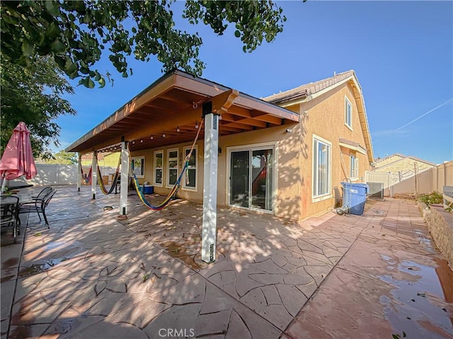 rear view of property with a patio and central AC