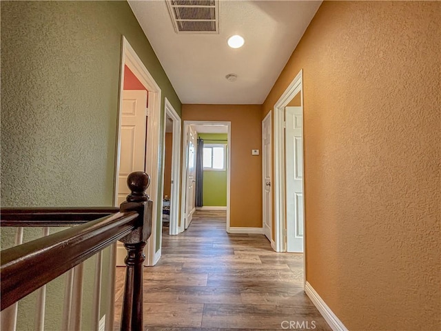 corridor with hardwood / wood-style floors