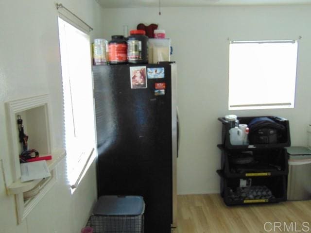 kitchen featuring black refrigerator and light hardwood / wood-style flooring