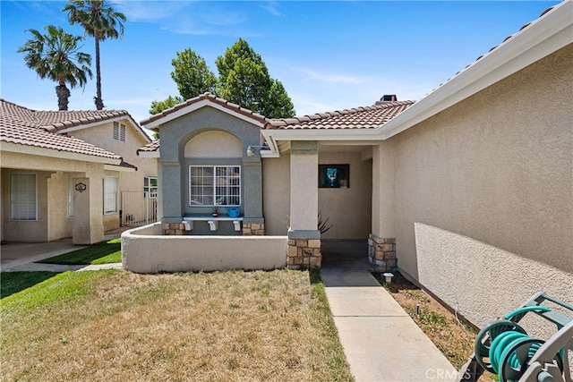 entrance to property with a lawn