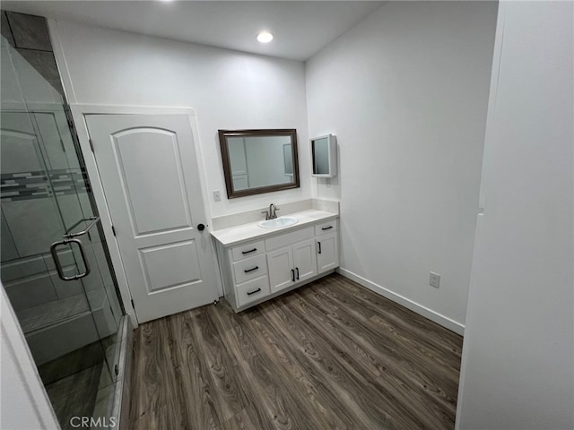 bathroom with walk in shower, vanity, and hardwood / wood-style flooring