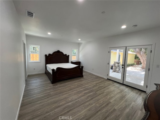 bedroom with dark hardwood / wood-style flooring, access to outside, and multiple windows