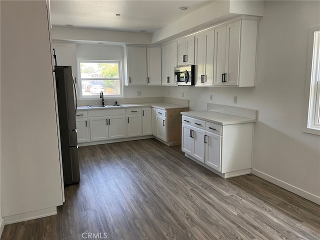 kitchen with sink, white cabinetry, stainless steel appliances, and dark wood-type flooring