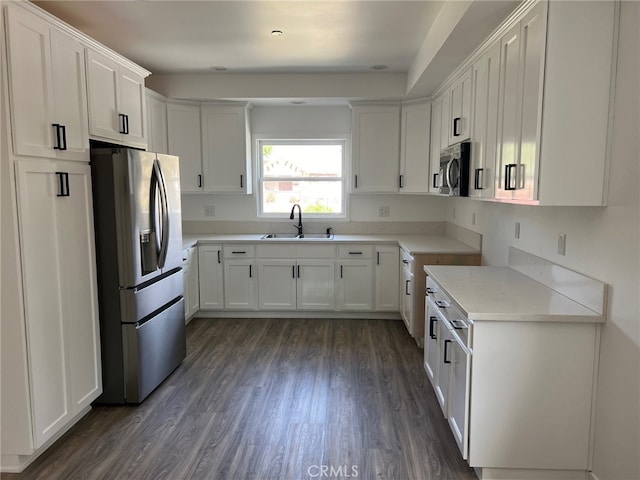 kitchen with white cabinets, dark hardwood / wood-style flooring, sink, and appliances with stainless steel finishes