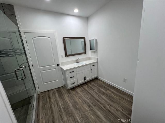 bathroom featuring hardwood / wood-style floors, vanity, and walk in shower