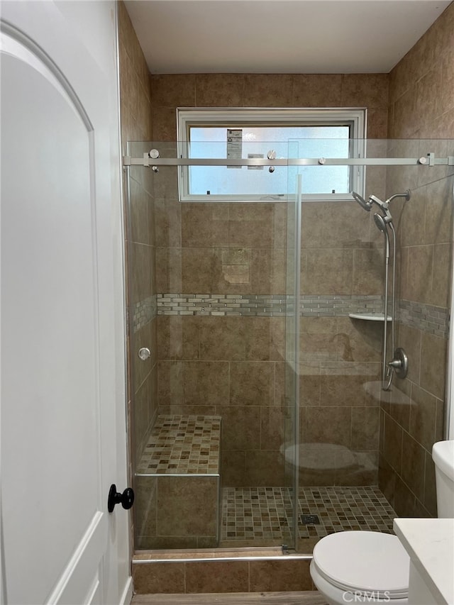 bathroom with walk in shower, vanity, a healthy amount of sunlight, and toilet