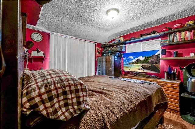 bedroom featuring wood-type flooring, a textured ceiling, and vaulted ceiling