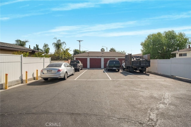 view of parking / parking lot featuring a garage