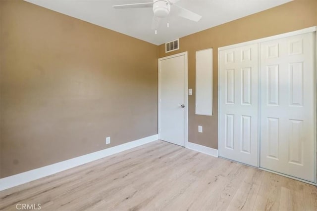 unfurnished bedroom featuring ceiling fan, a closet, and light hardwood / wood-style flooring