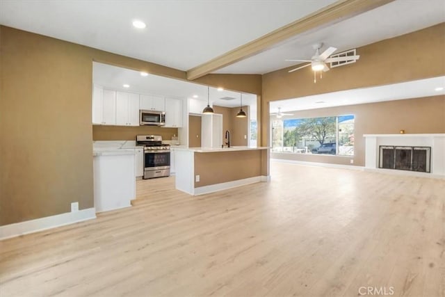 unfurnished living room with sink, light wood-type flooring, ceiling fan, and vaulted ceiling with beams