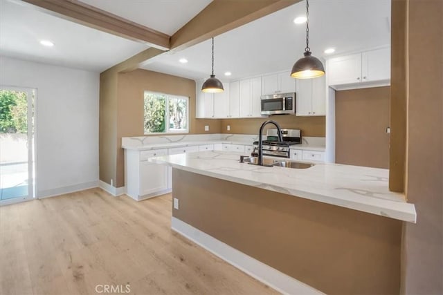 kitchen featuring light stone counters, hanging light fixtures, appliances with stainless steel finishes, and white cabinetry