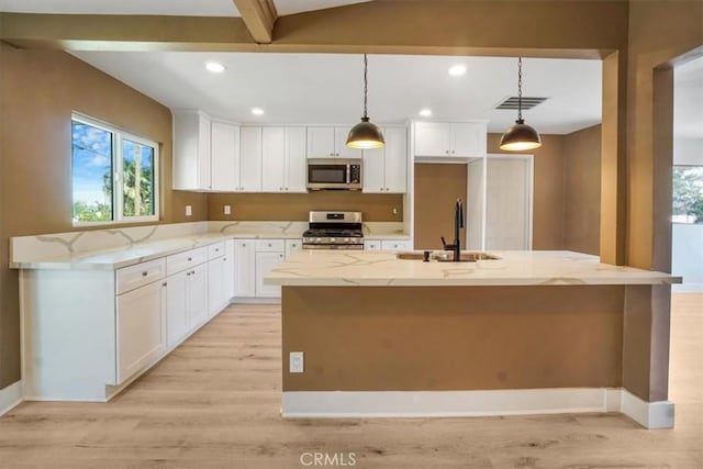 kitchen with light stone countertops, sink, a kitchen island with sink, and stainless steel appliances