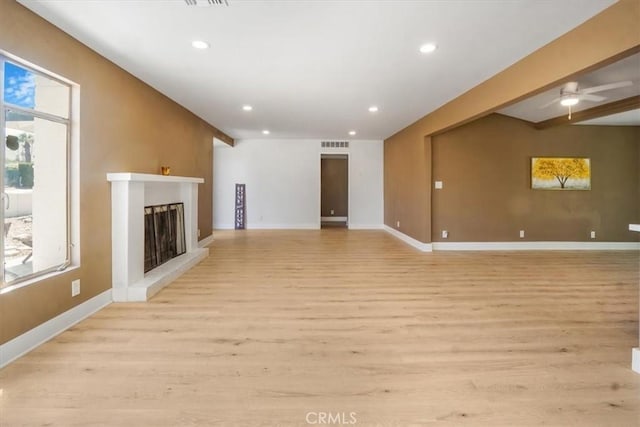 unfurnished living room featuring ceiling fan and light hardwood / wood-style floors