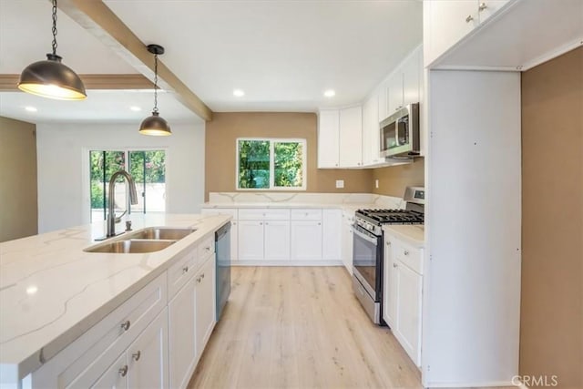 kitchen with sink, white cabinetry, appliances with stainless steel finishes, and hanging light fixtures