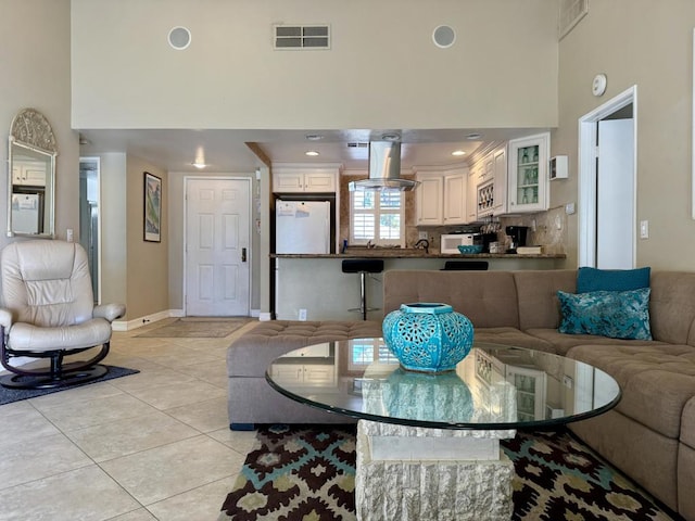 dining space featuring a high ceiling and light tile patterned floors