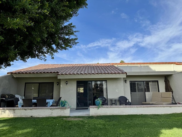 rear view of property with a lawn and a patio area