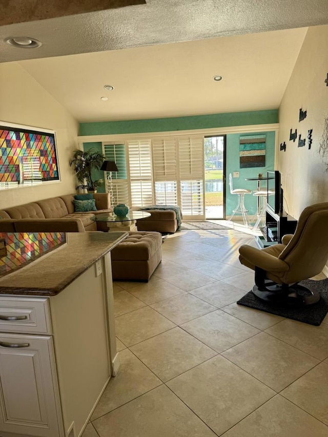 living room with light tile patterned floors and vaulted ceiling