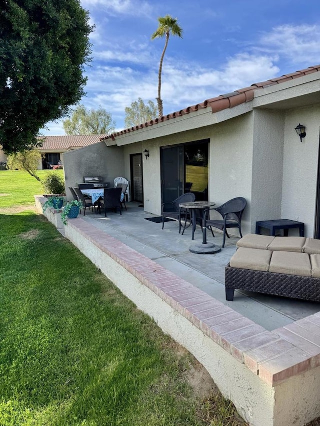 back of house with an outdoor living space, a lawn, and a patio