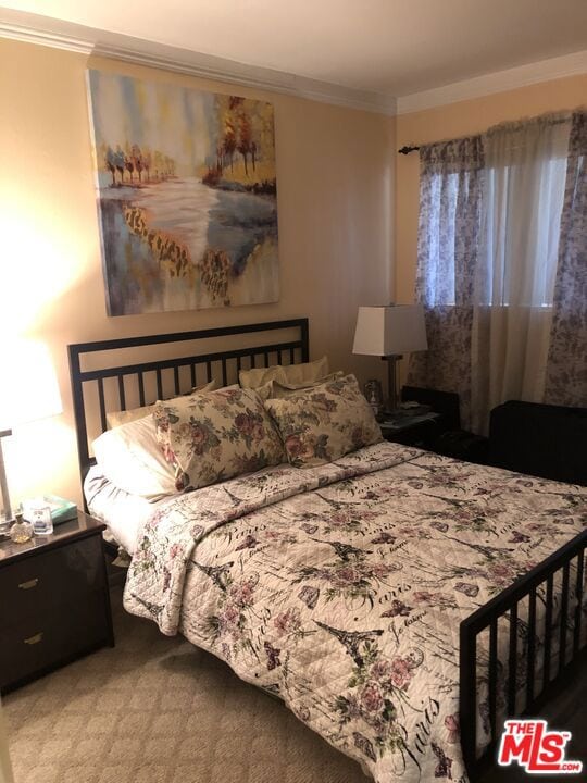 carpeted bedroom featuring crown molding