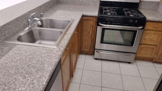 kitchen with light tile patterned floors, stainless steel appliances, and sink