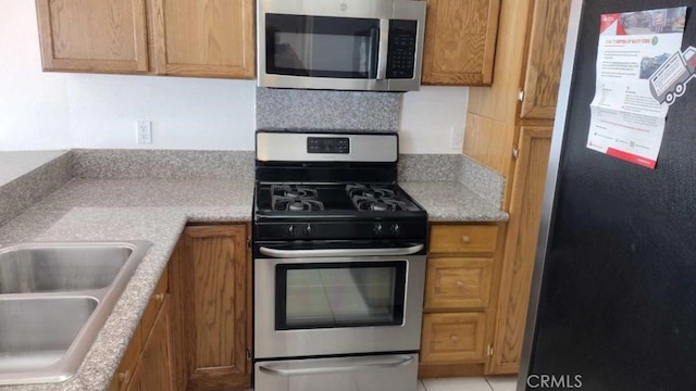 kitchen with sink, appliances with stainless steel finishes, and tasteful backsplash