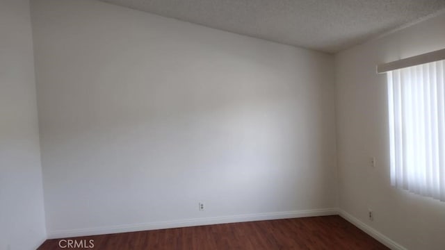 unfurnished room featuring dark hardwood / wood-style flooring and a textured ceiling