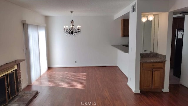 interior space featuring a textured ceiling, a notable chandelier, and dark wood-type flooring