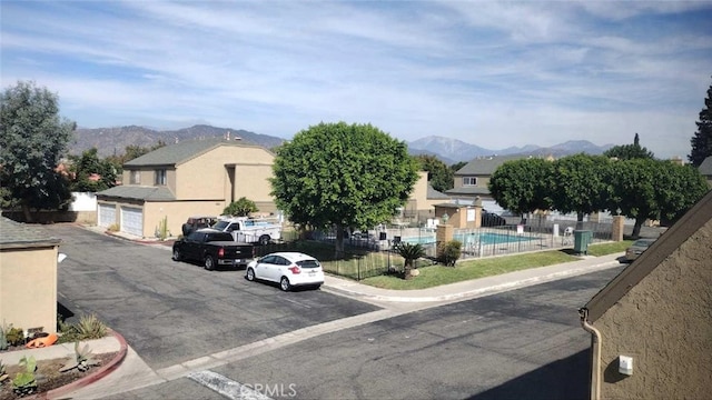 view of front of home featuring a fenced in pool and a mountain view