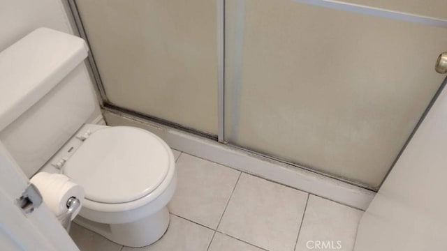 bathroom with tile patterned flooring, toilet, and walk in shower