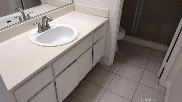 bathroom with walk in shower, tile patterned flooring, vanity, and toilet