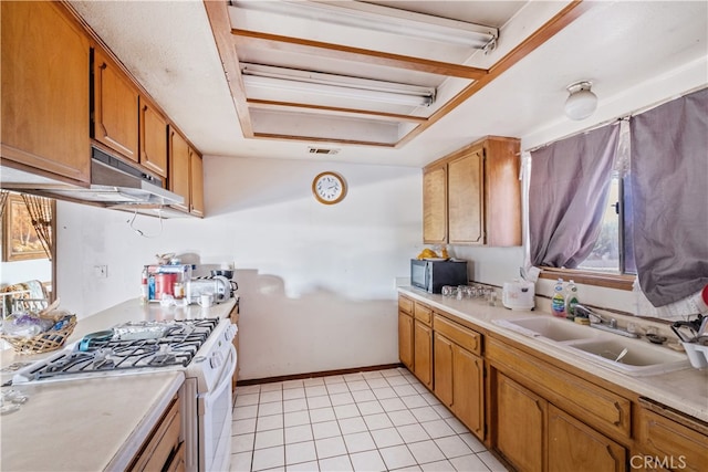 kitchen featuring gas range gas stove, sink, and light tile patterned floors