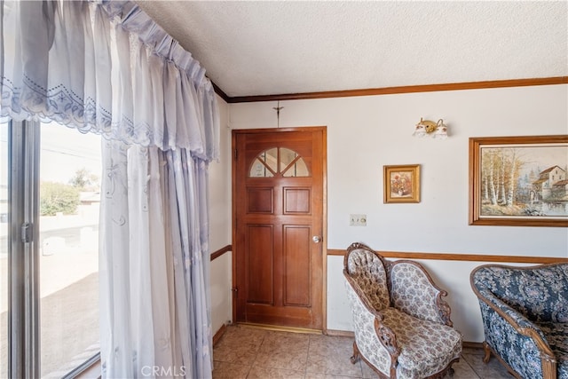 tiled entryway featuring crown molding and a textured ceiling