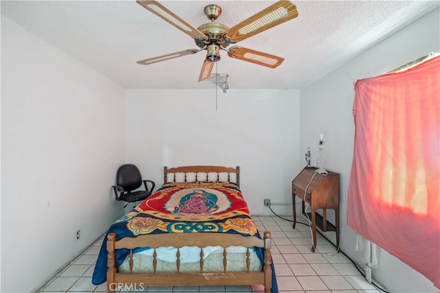 bedroom featuring a textured ceiling, light tile patterned floors, and ceiling fan