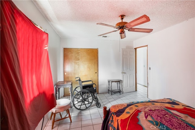 tiled bedroom featuring ceiling fan and a textured ceiling