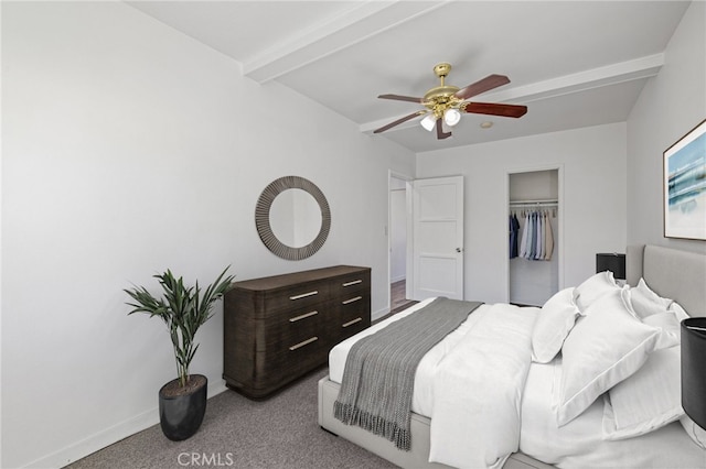 carpeted bedroom featuring a closet, beam ceiling, and ceiling fan