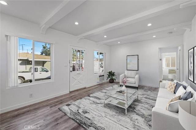 living room with a wall mounted air conditioner, hardwood / wood-style floors, and beamed ceiling