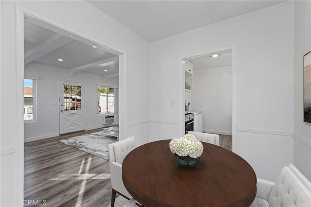 dining area featuring beamed ceiling and wood-type flooring