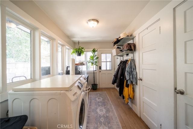 washroom featuring light hardwood / wood-style flooring, plenty of natural light, and washer and clothes dryer