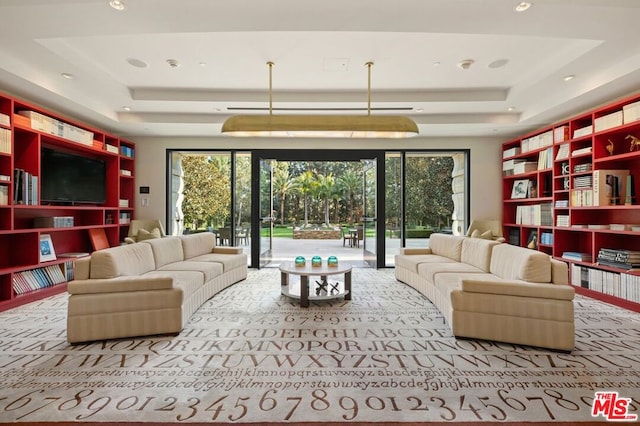 carpeted living room with a tray ceiling