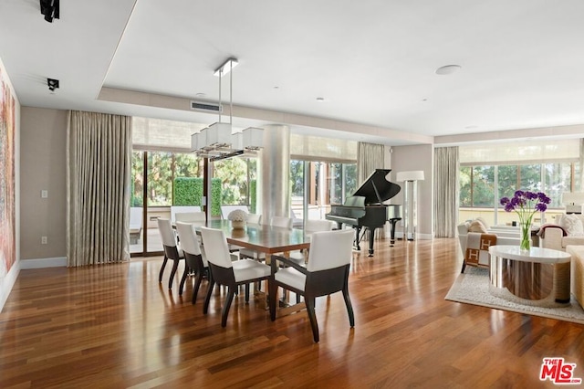 dining space with a notable chandelier, hardwood / wood-style flooring, and a healthy amount of sunlight